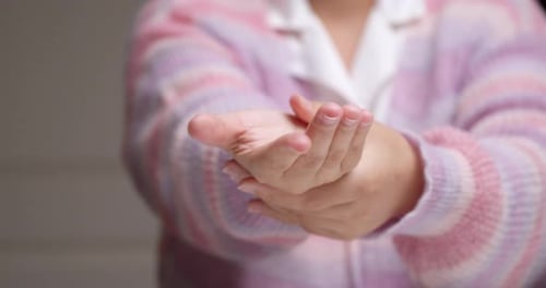 Nahaufnahme einer Frau mit Selbstmassage und Entspannungsarthritis, bei der Finger und Arm nach ihrer Hand gestreckt werden