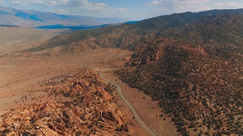 Highway passing among the craggy rocks and deserted landscape. Sunny day footage in the mountains