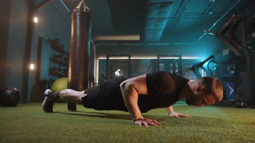 Focused Man in a Gym Doing Floor Pushups for Strength Training Session