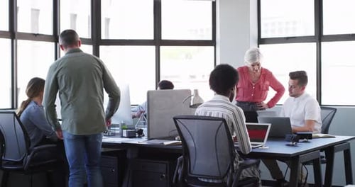 Manager, employees and office with computers, conversation and diversity in workplace