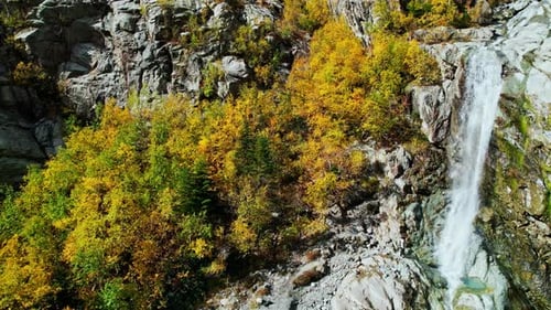 Aerial View On Beautiful Small Waterfall Flowing Out Cliff In Sunny Day Enjoying Beauty Of Nature