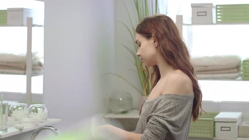Woman Rinsing Mouth With Teeth Rinse Front Mirror In Bathroom Before Sleep. Healthy Woman Using D...