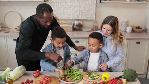 Mom and Dad Sharing Salad Recipe Multiracial Family Chatting Enjoying Time in Kitchen