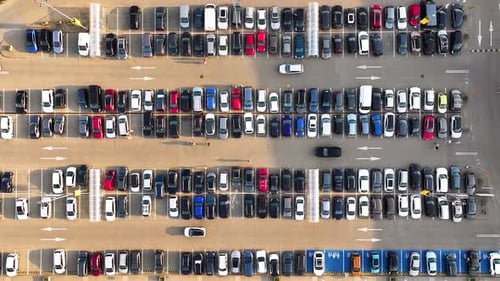 Large parking lot with many parked cars.