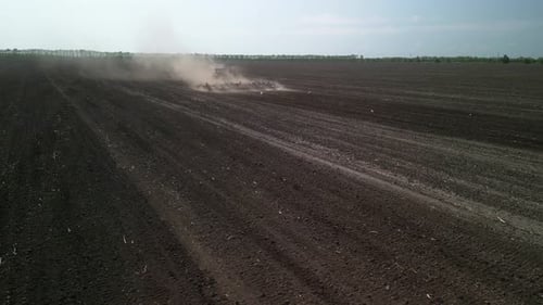 Roter Traktor arbeitet auf dem Feld zur Bodenbearbeitung in der Ukraine
