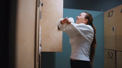 Un joueur de scène sportive détendu retirant son équipement pendant une photo intime d'un athlète dans un vestiaire calme