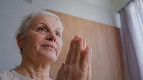 Senior Woman with Gray Hair Praying Indoors