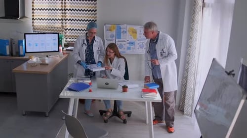 Doctors Consulting with Medical Papers in Hospital Office