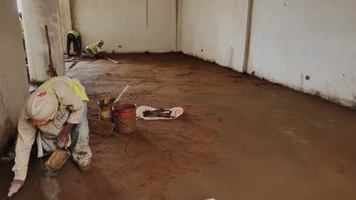 Labor Leveling Concrete On Site In Building Under Construction