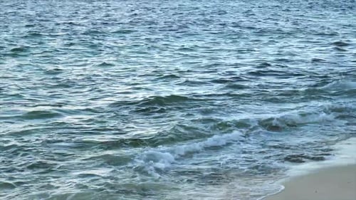 Sea Waves Splashing On The Sandy Shore At The Beach - close up