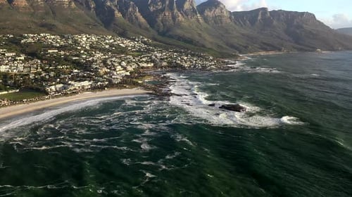 Cinematic Aerial Tilt Down Shot of Cape Town's Camps Bay at Sunset with Table Mountain in the Backgr
