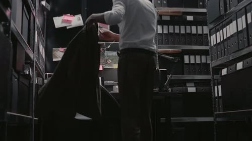 Detective Sits Down at Desk to Investigate Crime