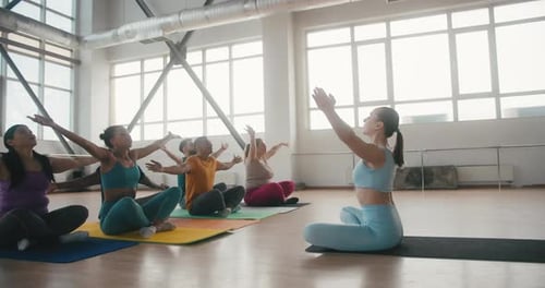 Yoga Class Performs Exercise in a Bright Studio