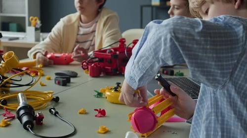 Boy Assembling Robotic Toy with Screwdriver in Stem Class