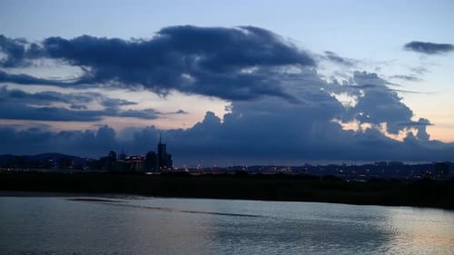 At dusk, the gorgeous sky and the silhouette of the city by the river.