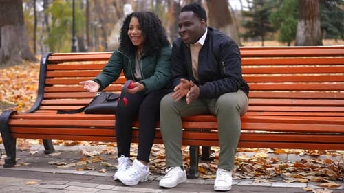 Couple Relaxing on Park Bench in the Fall