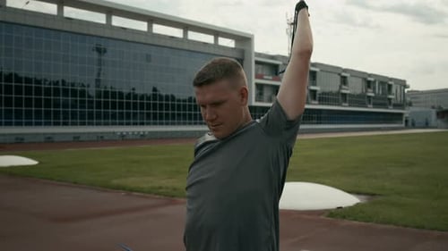 Athletic Man Stretching With Resistance Band Outdoors