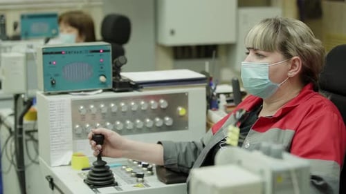 An Industrial Worker Operating a Control Panel While Wearing a Protective Mask for Safety Stock Clip