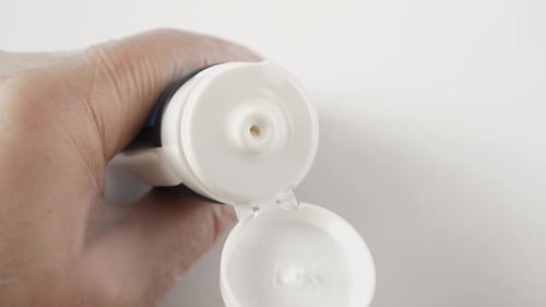 Cream Being Extracted from Tube with Wooden Stick