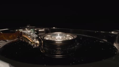 Open Hard Disk Drive with Shiny Head Reflecting Light