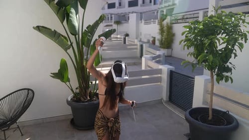 Woman Using VR Headset on Tropical Patio