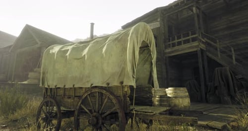 Old Wooden Wagon with a Cloth Cover Beside a Rustic Wooden Building