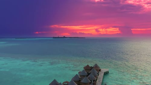 Overwater Villas at the Time Amazing Sunset in Tropical Sea with Coral Reef