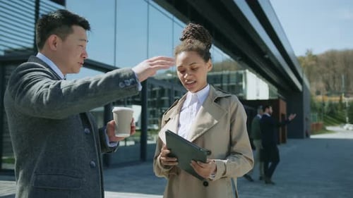 Business Professionals Discussing Technology Outside Office Building
