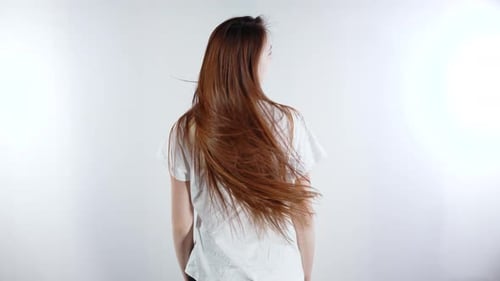 Auburn-Haired Woman Tossing Her Long Hair