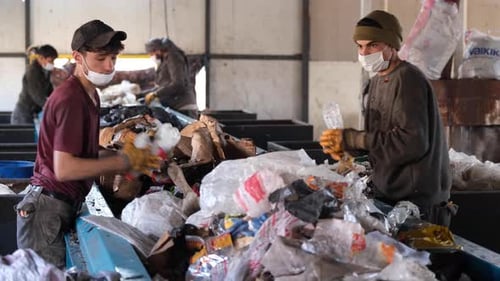 Masked Workers Sorting Garbage At Recycling Plant