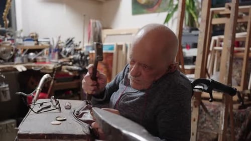 Senior Elderly Master Jeweler in Wheelchair Works in a Workshop