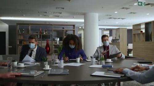 Multi ethnic entrepreneurs leave office wearing face masks after covid meeting