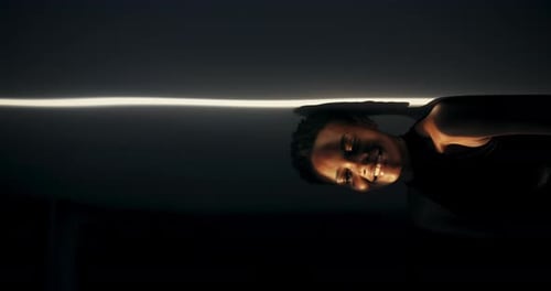 Young Adult Smiles in Dark Dramatic Lighting