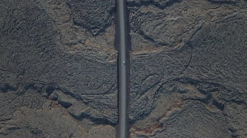 Top-down aerial view of a countryside secluded road in the middle of a breathtaking nature.