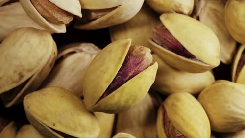 Salted pistachios in shell. Rotates. A scattering of pistachios. Close-up. View from above.