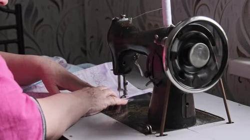 Woman Using Vintage Sewing Machine at Home