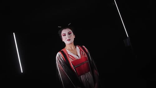 Schöne japanische Geisha posiert für die Kamera auf dunklem Hintergrund