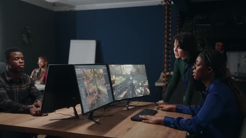 Multiethnic Team of Video Game Designers in Office Creating New Interface and Discussing