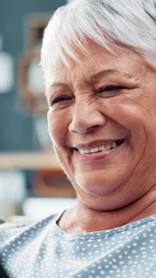 Senior woman, laughing and reading at house for social media, funny blog and information in lounge