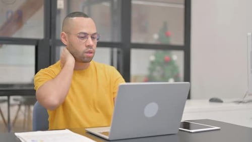 Man Working on Laptop Rubs Sore Neck