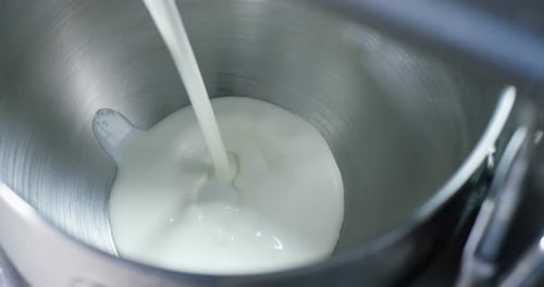 Tasty white cream stirs machine at professional factory making sweets, on white background. Concep