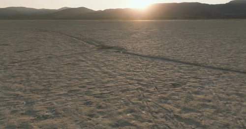 a large flat desert with mountains in the background