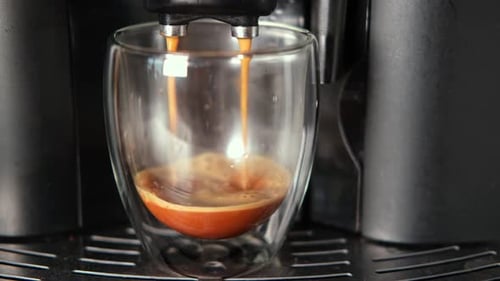 Hot Espresso Pours From Coffee Machine Into Glass