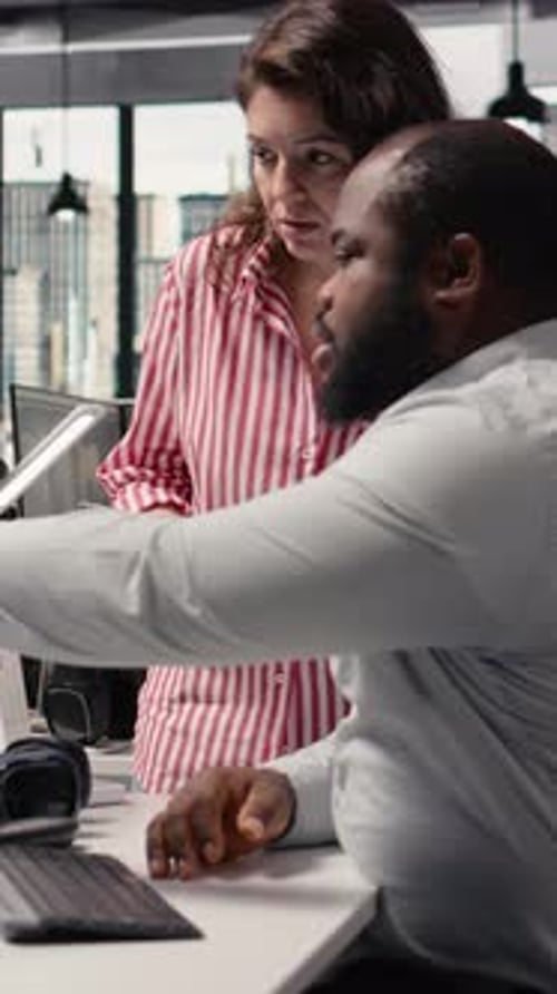 Teamwork in Office: Woman Explains Tablet to Man