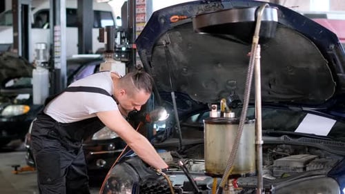 Auto Mechanic Repairs a Car in a Garage