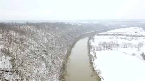 Vue aérienne d'un chariot lent au-dessus de la rivière brune Kentucky Ohio en hiver avec de la neige sur tout le sol