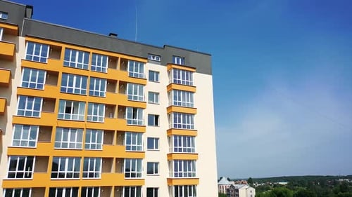 New multi-storey building in the city. Contemporary apartment building with large windows