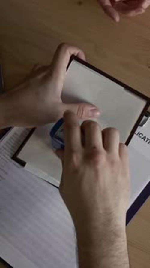 Visa Specialist Putting Approved Stamp on Applicants Passport, Handing It to Her