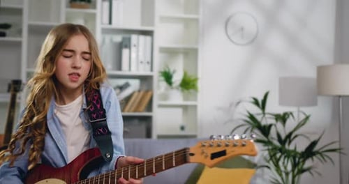 Teen Girl Plays Electric Guitar Energetically