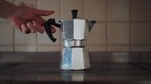 Close-up shot of vintage silver moka pot on the farmhouse stove. Italian way of coffee preparation.